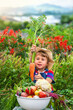 © yanadjan - Child with vegetables in the garden. Selective focus.