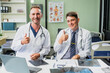 © NanSan - Caucasian middle-aged male doctor and Italian scientific researcher are seated at desk, discussing innovative antiviral drug inventions, with a monitor displaying the latest technology advancements.