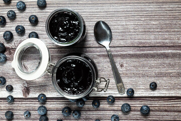 Tasty and healthy homemade blueberries marmalade. Top view of a table with a jar of homemade blueberries marmalade.