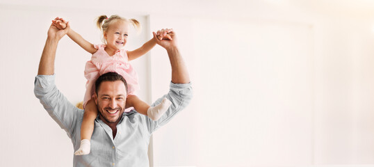 Happy Family. Little girl sitting on shoulders of her father, piggyback ride. Panorama, free space