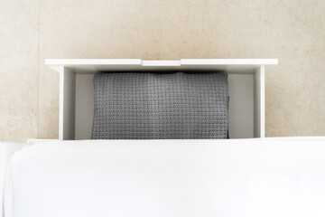 Wall Mural - Neatly organized storage drawer with a gray blanket in a modern interior