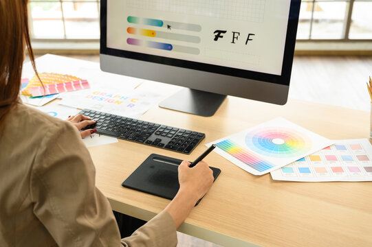 Asian female artist drawing something on graphic tablet. graphic designer working at office.