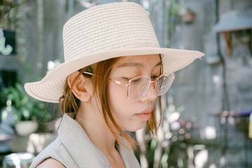 cute Balinese girl wearing glasses and hat close up outdoor photography