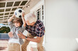 © Marko Geber - Grandfather and grandson playing with soccer ball on home porch