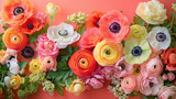 Colorful spring flowers in full bloom, including ranunculus and anemones, are arranged against a vibrant coral background.