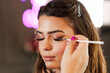 © Dusko - Professional beautician applying makeup on beautiful young woman's face. Professional make up studio work with gorgeous female model.