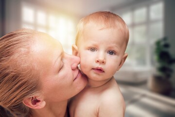 Tender happy young mother hugging newborn baby.