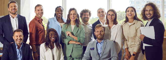 Wall Mural - Portrait of a group of diverse business multiethnic people men and women looking at camera and smiling. Happy cheerful company employees or group of staff standing in office. Banner.