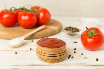 delicious ketchup with spices and tomatoes on wooden table