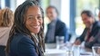 © VK Studio - A cheerful woman in a professional setting, smiling confidently amidst colleagues, embodying joy and success in a workplace atmosphere.