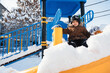 © alexkoral - A Caucasian child is having fun riding down a slide in winter