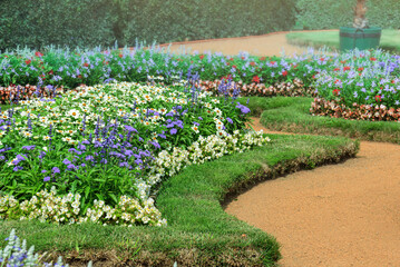 Flower garden with flowerbeds and winding paths in the historic city park