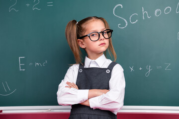 Wall Mural - Photo of cute little schoolgirl diligent crossed hands confident dressed stylish uniform classroom blackboard background