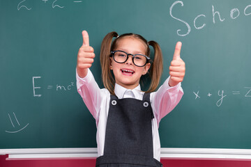 photo of charming little pupil girl thumb up approve wear trendy uniform classroom blackboard backgr