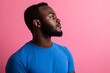 © Stanley - Thoughtful Young Man with Afro Looking Up Against Pink Background