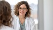 © Kethaka Shehan - young hispanic female doctor with warm smile, talking to patient in hospital, healthcare consultation, medical professional, copy space