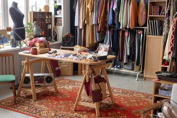 Wall Mural - Interior of thrift store or second hand shop selling pre owned clothing hanging on rack and fashion accessories displayed on table, copy space