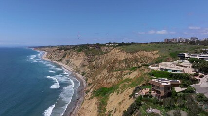 aerial view of paragliders flying over blacks beach by scripps pier in la jolla san diego on a sunny