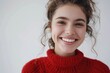 © Fotograf - A smiling woman wearing a cozy red sweater on a casual day