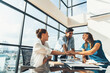 © InfiniteFlow - Group of skilled businesspeople putting hands together at modern office.Happy smart business team working together. Represented unity, love, team, working together, partnership, work place. Tracery.