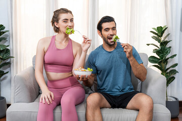 Healthy sporty and vegetarian couple in sportswear with a bowl of fruit and vegetable. Healthy cuisine nutrition and vegan lifestyle for fitness body physique at gaiety home concept.