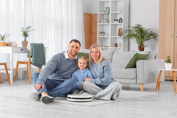 Poster - Happy family with robot vacuum cleaner hugging on floor at home