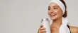 © raja - Portrait of sporty beautiful smiling lady in sportswear and white towel on neck holding shaker with healthy drink, whey protein, fresh water or coffee and looking away at free copy space banner mockup