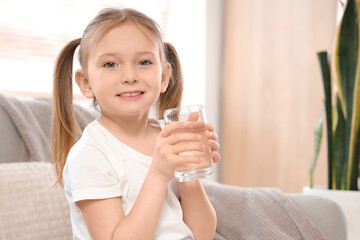 Wall Mural - Cute little girl with glass of water at home, closeup