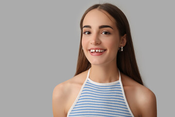 Wall Mural - Young woman with diastema smiling on light background, closeup