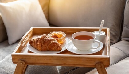 Wall Mural - breakfast tray with tea and croissant on couch