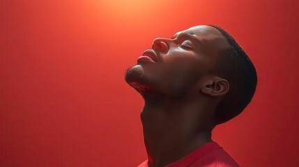 A mans face tilted upwards bathed in soft light