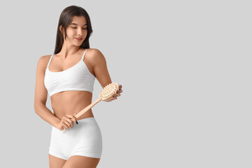 Poster - Young woman in underwear with cellulite problem and massage brush on light background