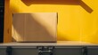 © Farid - Big cardboard box package on a grey truck ready to be delivered on yellow background.