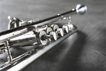 Sticker - Closeup view of shiny trumpet on grey textured table. Wind musical instrument