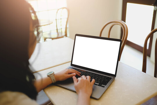 Close-up image of a woman sitting in the cafe and using her laptop.  laptop white blank screen mockup for display your graphic banner.