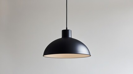 Poster - A detailed view of a minimalist pendant light with a single, matte black dome shade and a thin, elegant suspension cord, hanging against a light background.