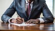 © Caitlin - African businessman signing legal document or contract