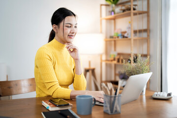 Wall Mural - Young attractive woman working on her project with laptop computer in modern home office room.