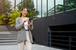 © Kittipong - Asian businesswoman talking on phone while sitting on outdoor stairs in city
