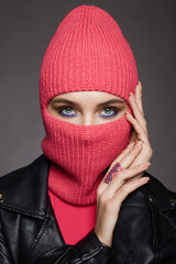 Wall Mural - beautiful girl in balaclava and leather coat. Trendy Mask on pretty woman