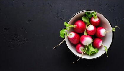 Wall Mural - Radish in a bowl on a black background, top view, copy space