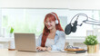 © wattana - Young stylish woman in headphone using laptop and professional microphone recording a podcast at home.