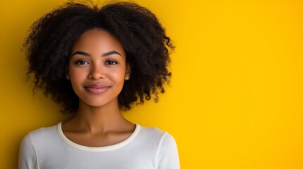 Sticker - A woman with curly hair is smiling at the camera. She is wearing a white shirt and standing in front of a yellow wall