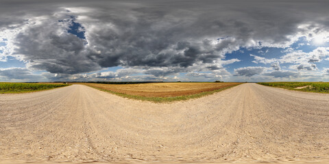 Wall Mural - 360 hdri panorama on roadside of gravel road with rain storm clouds in thunderstorm front dark sky in equirectangular spherical . seamless projection, as skydome replacement in drone panoramas