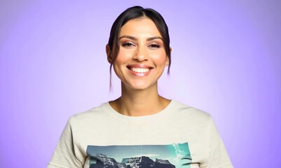 Wall Mural - Portrait of a beautiful young woman on a purple background smiling.