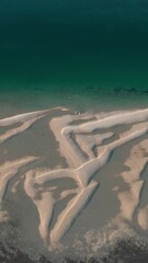 Wall Mural - Aerial vertical footage of a sandy beach after the tide on a sunny day in WA, Australia