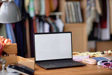 Wall Mural - Close up on laptop with blank white screen on wooden table at thrift store, copy space