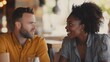 © uros - Young caucasian man talking with African American black woman at a cafe restaurant sitting at the table Multiethnic friendship Eating drinking together Date meeting Smiling people Couple in love