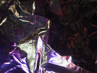 Wall Mural - purple light reflects on silver plastic sheet for abstract dark background.