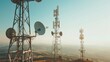 © VK Studio - Tall communication towers rise against a vast landscape, symbolizing connectivity and technological advancement, with a backdrop of a clear sky.